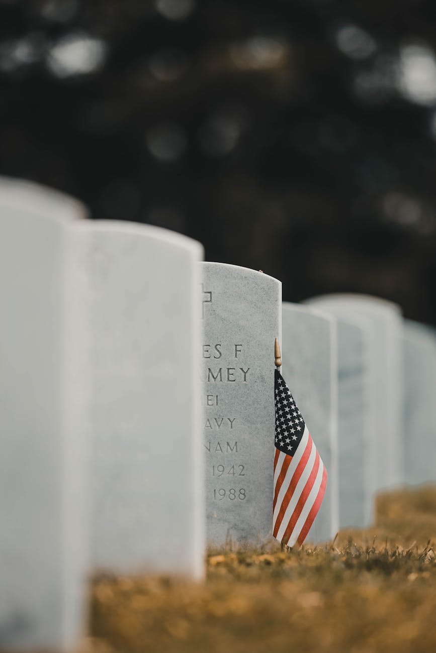 a flag beside the grave stone